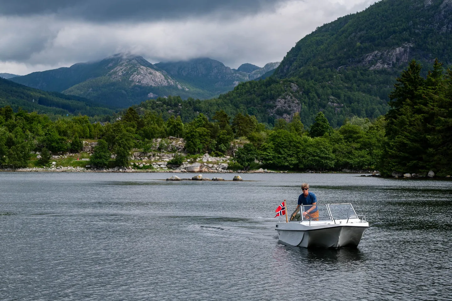 Trifoil 100GT moving across the water beneath mountains